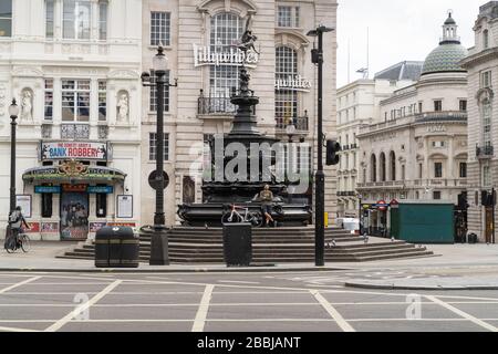 Un cycliste solitaire est vu sur les marches de la fontaine commémorative Shaftesbury, Piccadilly Circus pendant le verrouillage du Coronavirus au Royaume-Uni à Londres Banque D'Images