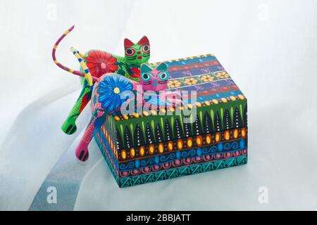 Boîte avec deux chats sculptés en bois et peints dans des couleurs et des points lumineux traditionnels à Oaxaca, au Mexique Banque D'Images