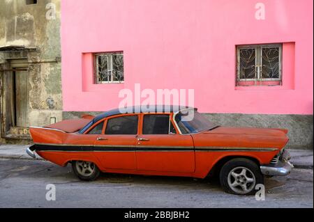 Mur rose avec ancienne voiture rouge américaine des années 50, Centro, la Havane, Cuba Banque D'Images