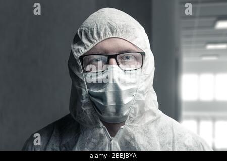 portrait du médecin avec combinaison de protection et lunettes cuites à la vapeur reflétant un couloir vide de l'hôpital Banque D'Images