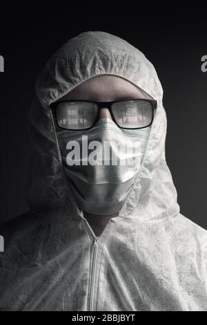 portrait du médecin avec combinaison de protection et lunettes cuites à la vapeur reflétant un couloir vide de l'hôpital Banque D'Images