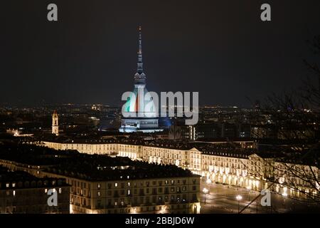 Le Mole Antonelliana est illuminé avec le drapeau italien pour se souvenir des nombreuses victimes de la pandémie de coronavirus. TURIN, ITALIE - MARS 2020 Banque D'Images