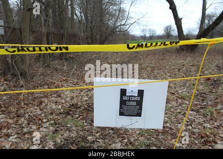 Ruban de police jaune et panneau fermé sur un parcours de golf de banlieue de Chicago pendant l'ordre d'hébergement du coronavirus Banque D'Images