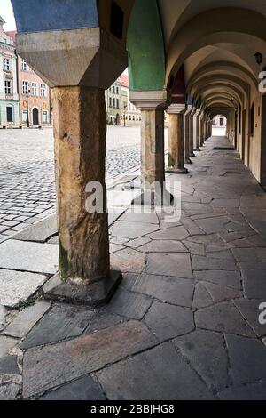 Une série de colonnes en pierre dans les arcades de maisons historiques de tenement sur la place du marché à Poznan Banque D'Images