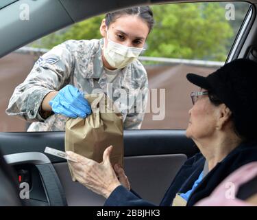 L'Airman Reanne Kohlus, Senior de la Force aérienne des États-Unis, remet une ordonnance à un patient âgé pendant le service de soins de curbside pour aider à COVID-19, soulagement de la pandémie de coronavirus à la base commune de San Antonio - Lackland le 30 mars 2020 à San Antonio, Texas. Banque D'Images