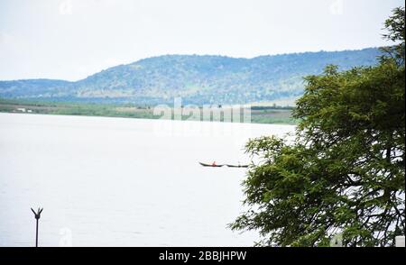 Deux bateaux dans un lac, avec des branches de foudre et d'arbres sur les rives Banque D'Images