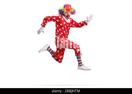 Clown dans un costume rouge à pois de polka sautant isolé sur fond blanc Banque D'Images