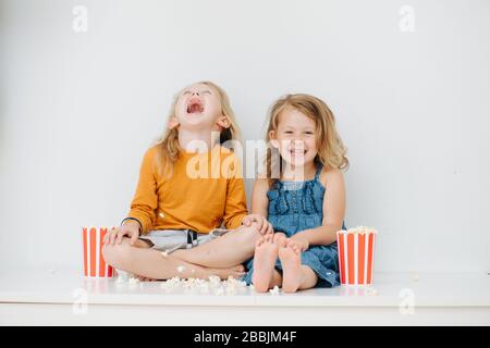 Deux enfants de la nauty ont jeté du pop-corn tout autour et rire Banque D'Images