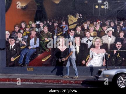 Homme marchant devant une fresque représentant les stars du cinéma hollywoodien, intitulée « You are the Star », par l'artiste Tom Suriya sur Cahuenga Blvd. À Hollywood, Californie Banque D'Images