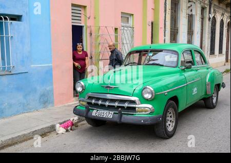 Vieux Chevrolet et chien, avec couple, la Havane, Cuba Banque D'Images