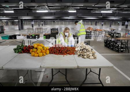 (200401) -- LONDRES, 1er avril 2020 (Xinhua) -- les bénévoles préparent de la nourriture et des repas dans un centre de distribution situé dans le parking souterrain de Tottenham Hotspur Stadium à Londres, Grande-Bretagne, 31 mars 2020. Le pôle de distribution a été créé par l'organisme de bienfaisance comestibles London, en partenariat avec le Haringey Council, pour la distribution des aliments aux groupes vulnérables et aux travailleurs du National Health Service (NHS). Le gouvernement britannique continue d'essayer de lutter contre l'épidémie de COVID-19, tandis que les autorités locales, les groupes communautaires et les organismes de bienfaisance travaillent à fournir de la nourriture aux plus vulnérables de la société. (Photo Banque D'Images