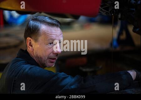 Berlin, Allemagne. 31 mars 2020. Andreas Lemmer, mécanicien automobile et propriétaire de son atelier, démonte le pneu d'une voiture. Crédit: Fabian Sommer/dpa/Alay Live News Banque D'Images