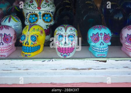 Une rangée de crânes de sucre colorés à vendre dans une vitrine de magasin Banque D'Images