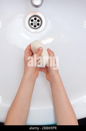 Laver les mains de l'enfant avec du savon antibactérien sur le lavabo blanc. Protection contre les bactéries, coronavirus. Banque D'Images