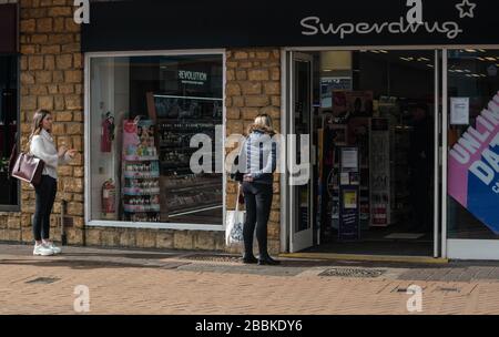 Des files d'attente décalées à l'extérieur des magasins, afin de se conformer aux mesures de distanciation sociale mises en place par le gouvernement britannique. Pandémie de coronavirus. Banque D'Images