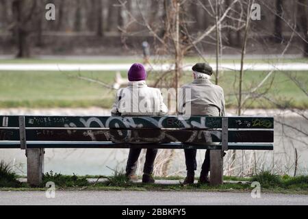 Munich, Allemagne. 01 avril 2020. Un retraité et une femme s'assoient sur un banc sur les rives de l'Isar à Muenchen-Lehel. | utilisation dans le monde crédit: dpa/Alay Live News Banque D'Images