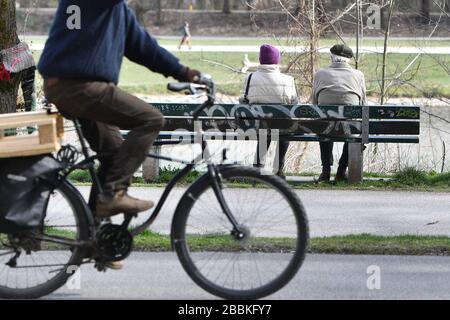 Munich, Allemagne. 01 avril 2020. Un retraité et une femme s'assoient sur un banc sur les rives de l'Isar à Muenchen-Lehel. | utilisation dans le monde crédit: dpa/Alay Live News Banque D'Images