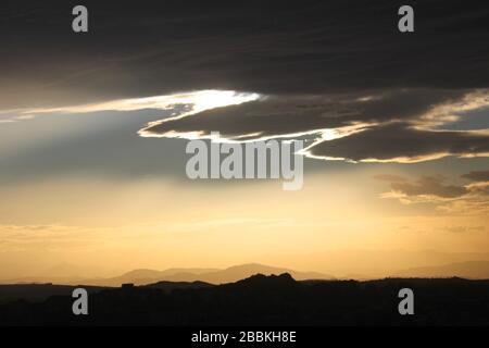 Soleil clair de la fin de l'après-midi obscurci par des nuages sombres avec un Doublure argent avec la chaîne de montagnes Picos de Europa de Santander Cantabrie Espagne Banque D'Images