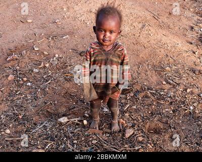 Samburu, Kenya - Août 2014: Portrait d'un jeune enfant africain avec de beaux yeux lumineux, regardant l'appareil photo Banque D'Images