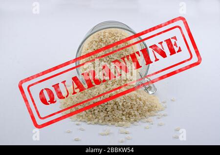 Panneau de quarantaine sur le riz sec dans la tasse en verre isolé sur fond blanc. Riz renversé. Banque D'Images