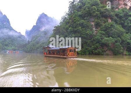 Excursions en bateau sur le lac Baofeng avec forêt luxuriante entourant les hauts sommets de pierre dans la zone panoramique de Wulinguan près de Zhangjiajie, province de Hunan, Chine Banque D'Images