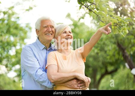 Un couple souriant de personnes âgées dans le parc Banque D'Images