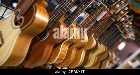 Gros plan sur une arrenge énorme de mandoline de bois drappée dans une rangée dans un musical, un magasin d'instruments, un concept d'instrument Banque D'Images