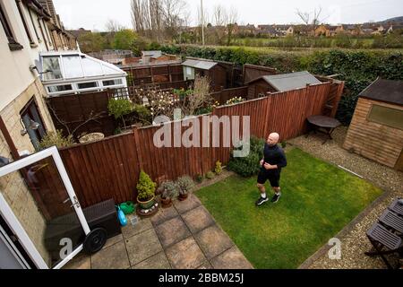 James Campbell, 31 ans, qui est en train de courir un marathon de 26,2 milles dans son jardin à Cheltenham, Gloucestershire tout en étant en verrouillage. Banque D'Images