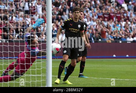 John Stones de Manchester City se présente comme le gardien de but de Manchester City, Ederson, fait des économies Banque D'Images