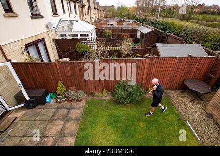 James Campbell, 31 ans, qui est en train de courir un marathon de 26,2 milles dans son jardin à Cheltenham, Gloucestershire tout en étant en verrouillage. Banque D'Images