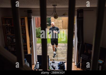 James Campbell, 31 ans, qui est en train de courir un marathon de 26,2 milles dans son jardin à Cheltenham, Gloucestershire tout en étant en verrouillage. Banque D'Images