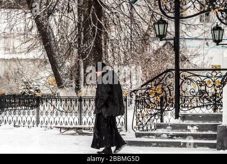 Kazan, Russie - 1 janvier 2020: Cathédrale orthodoxe de la Trinité dans le monastère de Raifa en hiver. Un prêtre marche une journée d'hiver calme à travers t Banque D'Images