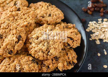 Biscuits au gruau faits maison avec raisins secs sur un fond sombre Banque D'Images