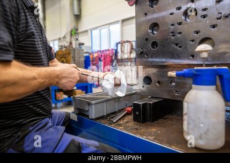 Ingénieur en maintenance du moule d'injection après la production, nettoyage du moule d'injection, concept industriel Banque D'Images