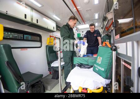 Le pompier Dominic Pearce de la London Fire Brigade (à droite) et le paramédic Daniel Phillips du London Ambulance Service préparent une ambulance pour l'utilisation au siège du London Ambulance Service alors que les pompiers participent à la formation pour se préparer à aider avec un certain nombre de rôles, y compris la conduite d'ambulances, au cours de l'éclosion de coronavirus. Banque D'Images