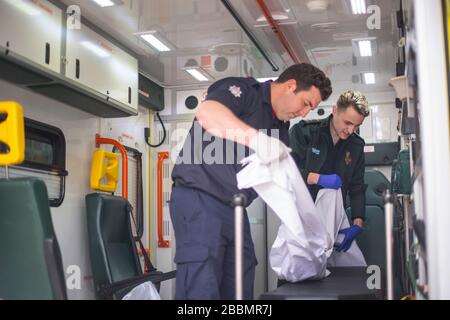 Le pompier Dominic Pearce de la London Fire Brigade (à gauche) et le paramédic Daniel Phillips du London Ambulance Service préparent une ambulance pour une utilisation au siège du London Ambulance Service alors que les pompiers participent à la formation pour se préparer à aider à un certain nombre de rôles, y compris la conduite d'ambulances, au cours de l'éclosion de coronavirus. Banque D'Images