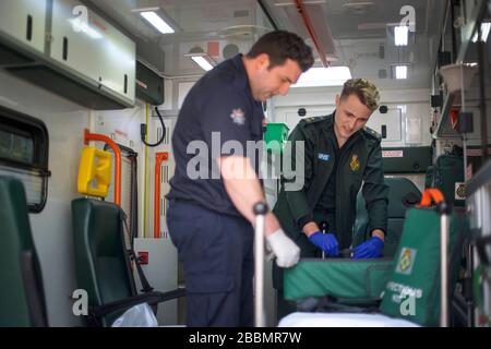 Le pompier Dominic Pearce de la London Fire Brigade (à gauche) et le paramédic Daniel Phillips du London Ambulance Service préparent une ambulance pour une utilisation au siège du London Ambulance Service alors que les pompiers participent à la formation pour se préparer à aider à un certain nombre de rôles, y compris la conduite d'ambulances, au cours de l'éclosion de coronavirus. Banque D'Images
