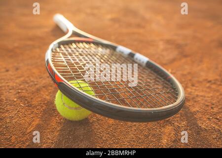 Gros plan sur la raquette de tennis avec une balle sur l'argile de tennis, concept de sport Banque D'Images