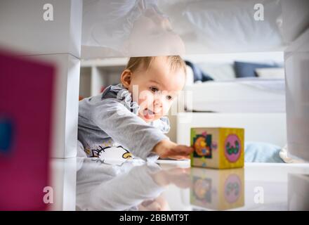 Bébé doux se pressant dans l'espace serré pour obtenir ce qu'elle veut. Banque D'Images