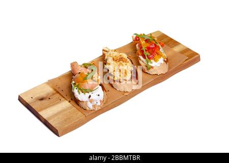 Bruschetta avec saumon sur un panneau de bois sur fond blanc. Pain grillé avec avocat et poisson rouge. Le concept est utile et délicieux petit déjeuner Banque D'Images