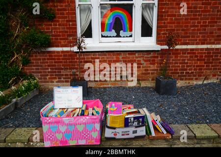 1 avril 2020, Southborough, Kent, Royaume-Uni: Libre échange de livres / bibliothèque de prêt sur le mur avant à l'extérieur de la maison pendant le gouvernement a imposé la quarantaine / le verrouillage pour réduire la propagation du coronavirus. Les enfants de tout le pays ont mis des dessins d'arcs-en-ciel dans des fenêtres pour répandre l'espoir et encourager les gens à rester enjoués pendant la pandémie. Ils ont aussi eu des idées pour empêcher les autres de s'ennuyer, dans ce cas encourageant la lecture et fournissant des moyens de se tenir des différents livres à lire Banque D'Images