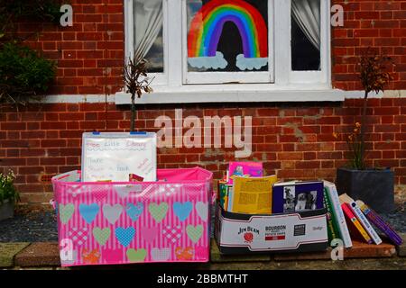 1 avril 2020, Southborough, Kent, Royaume-Uni: Libre échange de livres / bibliothèque de prêt sur le mur avant à l'extérieur de la maison pendant le gouvernement a imposé la quarantaine / le verrouillage pour réduire la propagation du coronavirus. Les enfants de tout le pays ont mis des dessins d'arcs-en-ciel dans des fenêtres pour répandre l'espoir et encourager les gens à rester enjoués pendant la pandémie. Ils ont aussi eu des idées pour empêcher les autres de s'ennuyer, dans ce cas encourageant la lecture et fournissant des moyens de se tenir des différents livres à lire Banque D'Images