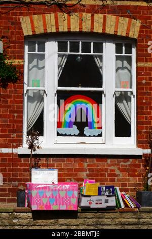 1 avril 2020, Southborough, Kent, Royaume-Uni: Libre échange de livres / bibliothèque de prêt sur le mur avant à l'extérieur de la maison pendant le gouvernement a imposé la quarantaine / le verrouillage pour réduire la propagation du coronavirus. Les enfants de tout le pays ont mis des dessins d'arcs-en-ciel dans des fenêtres pour répandre l'espoir et encourager les gens à rester enjoués pendant la pandémie. Ils ont aussi eu des idées pour empêcher les autres de s'ennuyer, dans ce cas encourageant la lecture et fournissant des moyens de se tenir des différents livres à lire Banque D'Images