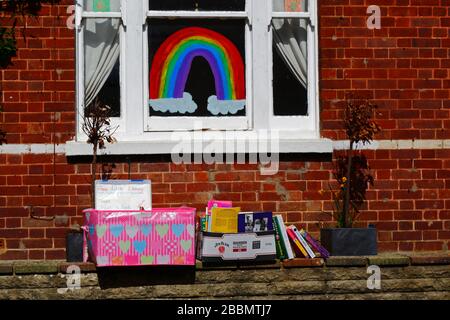 1 avril 2020, Southborough, Kent, Royaume-Uni: Libre échange de livres / bibliothèque de prêt sur le mur avant à l'extérieur de la maison pendant le gouvernement a imposé la quarantaine / le verrouillage pour réduire la propagation du coronavirus. Les enfants de tout le pays ont mis des dessins d'arcs-en-ciel dans des fenêtres pour répandre l'espoir et encourager les gens à rester enjoués pendant la pandémie. Ils ont aussi eu des idées pour empêcher les autres de s'ennuyer, dans ce cas encourageant la lecture et fournissant des moyens de se tenir des différents livres à lire Banque D'Images