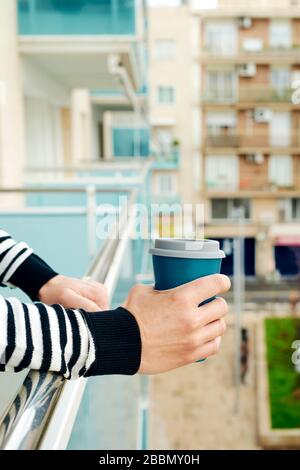 gros plan d'un jeune homme caucasien, portant des vêtements décontractés, ayant un café dans le balcon de sa maison ou d'un hôtel Banque D'Images