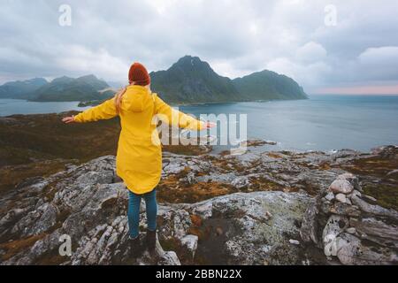 Femme voyageur a levé les mains profitant de la vue sur les montagnes pluvieuses voyager en Norvège vacances actives vie saine plein air îles Lofoten paysaga Banque D'Images