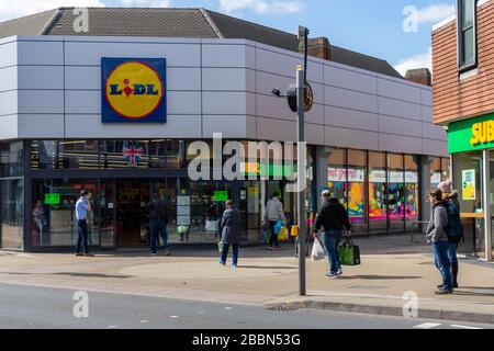 Des clients font la queue devant un supermarché Lidl situé à deux mètres l'un de l'autre Banque D'Images