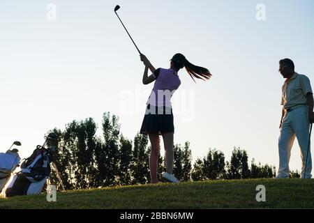 Les jeunes femmes et les personnes âgées pour jouer au golf Banque D'Images