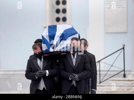 Athènes, Grèce. 1 er avril 2020. Les barbes de cercueils, portant des masques et des gants de protection noirs, détiennent le cercueil du héros et politicien de la résistance du Worl Greek War II, Manolis Glezos, lors de ses funérailles auxquelles ont assisté uniquement des membres de sa famille, par mesure de précaution contre la propagation de la pandémie de coronavirus de Covid-19, à Athènes, Grèce. Manolis Glezos le 30 mai 1941, à l'âge de 18 ans, a grimpé avec Apostolos Santas sur l'Acropole et a torqué le drapeau de la swastika, trois jours après que les forces nazies ont occupé Athènes et sont devenues un symbole de la résistance anti-nazie grecque et internationale. Le politicien de gauche grec, qui est confronté Banque D'Images