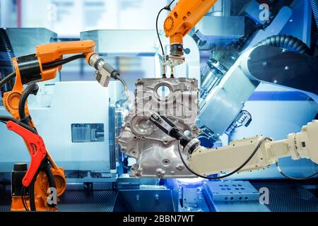 Soudage robotisé industriel, préhension de robot et balayage 3-D robotisé fonctionnant avec des pièces automatiques sur une usine intelligente, sur fond couleur bleu de la machine. Banque D'Images